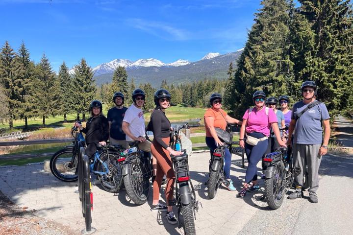 a group of people standing next to a bicycle
