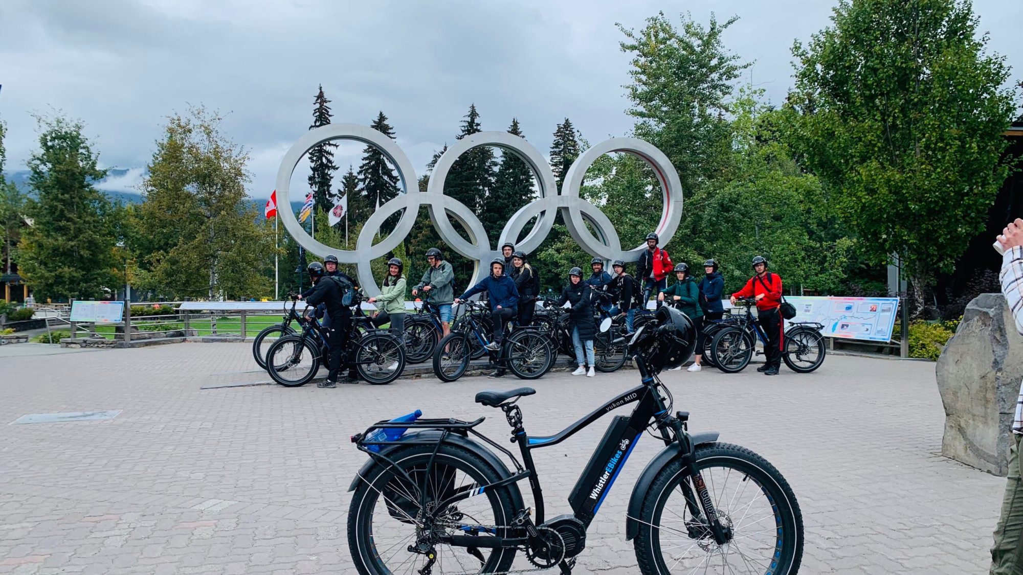 a group of people standing in front of a bicycle