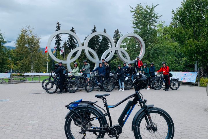 a group of people standing in front of a bicycle