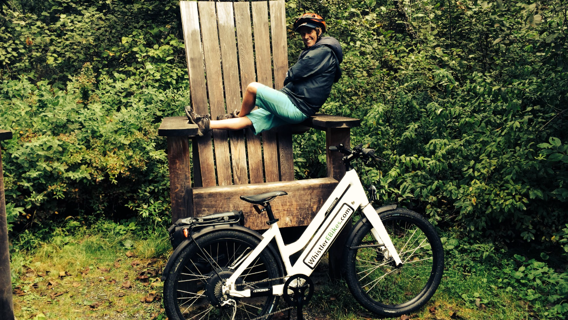 man on wooden chair with bike
