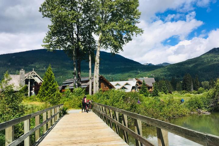 people biking on a trail with scenic mountains